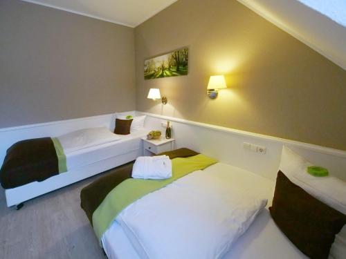 a room with two beds in a room at Waldhotel Wilhelmshöhe in Freudenberg