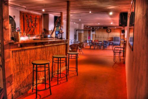 un bar con sgabelli e tavoli in una stanza di Agriturismo La Finca a Cresciano