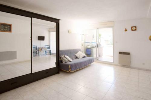 uma sala de estar com um sofá e uma porta de vidro em T1 Bandol Renécros 3 étoiles à 2 pas de la plus belle plage em Bandol