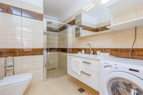 a bathroom with a washing machine and a shower at Luxury apartments Kostrena with pool in Kostrena