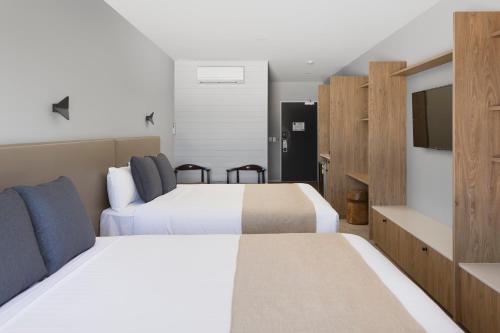 a hotel room with two beds and a flat screen tv at Abode Murrumbateman in Murrumbateman
