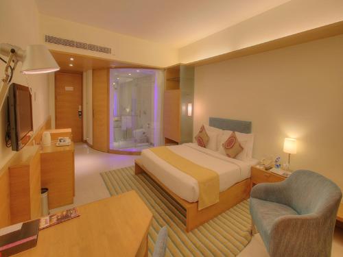 a hotel room with a bed and a television at Hotel Parc Estique in Pune