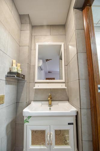 a bathroom with a sink and a mirror at Chaozhou Hello Inn in Chaozhou