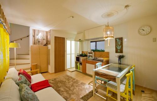 ein Wohnzimmer mit einem Sofa und einem Tisch sowie eine Küche in der Unterkunft Lucy's House横浜中華街 House1 in Yokohama