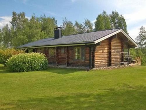 uma cabana de madeira num campo de relva verde em Holiday Home 5650 by Interhome em Koskenpää