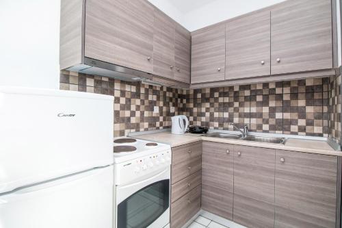 a kitchen with wooden cabinets and a white stove top oven at Toulas Studios & Apts No2 in Faliraki