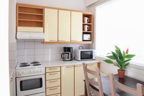 a small kitchen with a table and a microwave at Apartment Raisio City Center host by B&B Tuure in Raisio