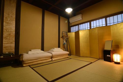 een kamer met 2 bedden en een tv. bij Guest House Bokuyado in Kyoto