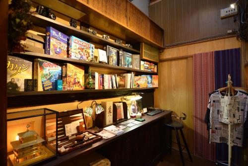 een kamer met een boekenplank met boeken en een bureau bij Guest House Bokuyado in Kyoto