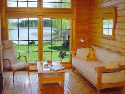 ein Wohnzimmer mit einem Sofa, einem Tisch und Fenstern in der Unterkunft Holiday Home Hämeenhelmi by Interhome in Pätiälä