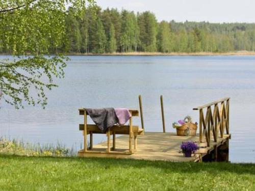 eine Bank, die auf einem Steg auf einem See sitzt in der Unterkunft Holiday Home Hämeenhelmi by Interhome in Pätiälä