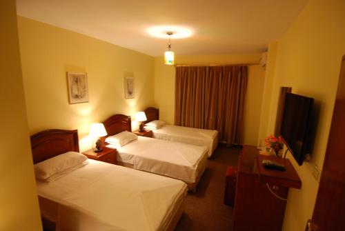 a hotel room with two beds and a television at Al Rashid Hotel in Wadi Musa