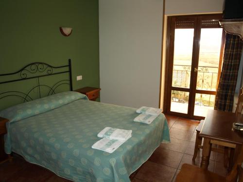 a bedroom with a bed and a door to a balcony at El Churrón in Larrés
