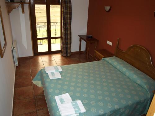 a bedroom with a bed with a green comforter at El Churrón in Larrés
