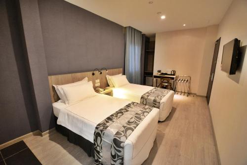 a hotel room with two beds and a table at Diamond Inn in Kota Kinabalu