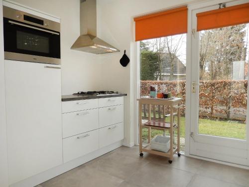 a kitchen with white cabinets and a window at Holiday Home Stern Comfort-2 by Interhome in Noordwijk