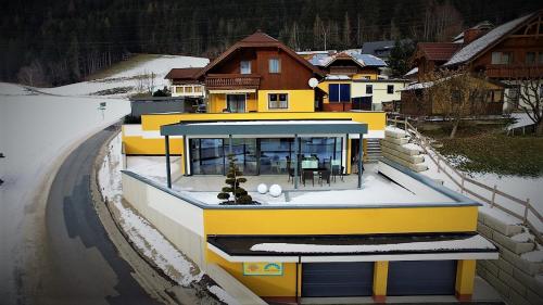 a yellow house on a snow covered road at Sun Chalet in Schladming