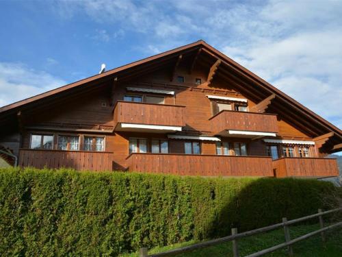 a large wooden house with a fence in front of it at Apartment Simmental by Interhome in Zweisimmen