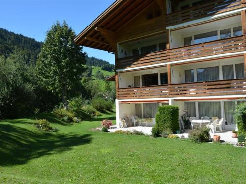 une grande maison avec une pelouse devant elle dans l'établissement Apartment La Sarine 222 by Interhome, à Gstaad