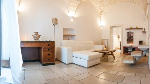 a living room with a white couch and a table at Via Roma in Ostuni