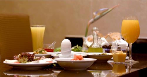 a table with plates of food and glasses of orange juice at Imperial Suites Hotel in Beirut