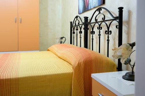 マリーナ・ディ・マンカヴェルサにあるBaccaversa camereのベッドルーム1室(黄色い毛布付きのベッド1台付)