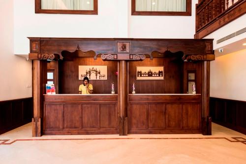 a person standing behind a bar in a building at Regenta Central Herald Mysore in Mysore
