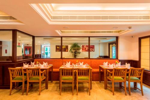 a dining room with tables and chairs in a restaurant at Regenta Central Herald Mysore in Mysore