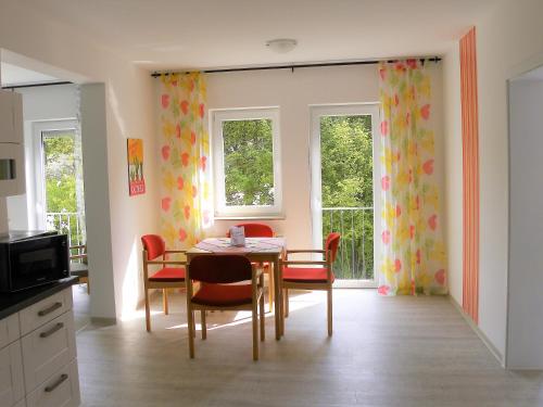 a dining room with a table and chairs and windows at Ferienwohnung im Haus "Maria Anna" in Bad Ems