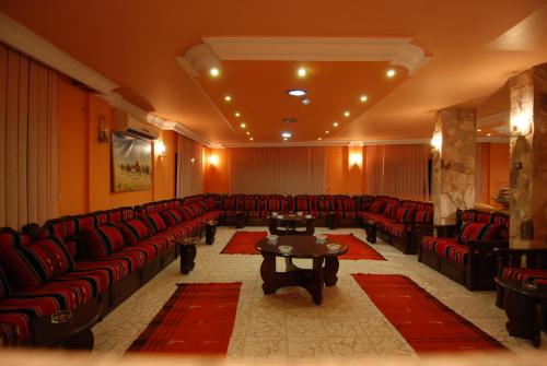 ein großes Wartezimmer mit roten Stühlen und einem Tisch in der Unterkunft Al Rashid Hotel in Wadi Musa