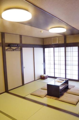 an empty room with a table and some windows at Ryoso Chatani in Kyoto