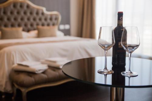 a bottle of wine and two wine glasses on a table at Hotel Datini in Prato