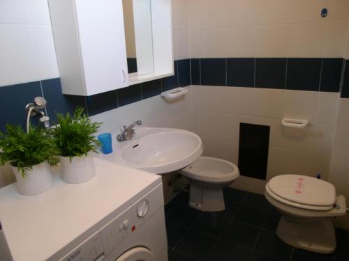 a bathroom with a white sink and a toilet at Condominio Alto Adriatico in Grado