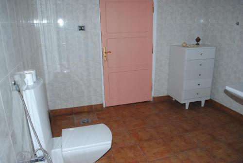 a bathroom with a toilet and a pink door at Nubian Holiday House Aswan in Aswan