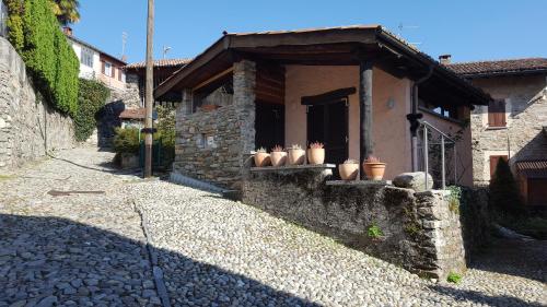 ein Steingebäude mit Vasen an einer Steinmauer in der Unterkunft Rustico in Miglieglia