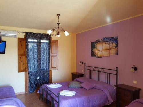 a bedroom with two beds and a tv in it at Hotel Il Cortile in Custonaci