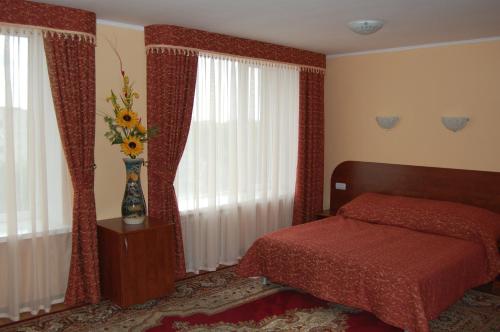 コーヴェリにあるRP hotel Лісова пісняのベッドルーム1室(ベッド1台、テーブルの上に花瓶1枚付)