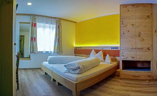 sypialnia z 2 łóżkami i żółtą ścianą w obiekcie Drei Birken w mieście Soprabolzano