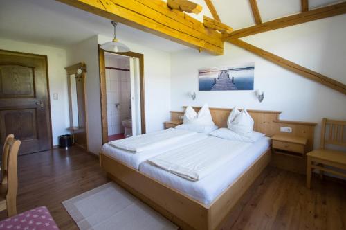 a bedroom with a large bed with white sheets at Bauernhof Kasleitner in Zell am Moos