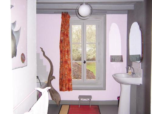 uma casa de banho com um lavatório e uma janela em Mistoury em La Tour-Blanche