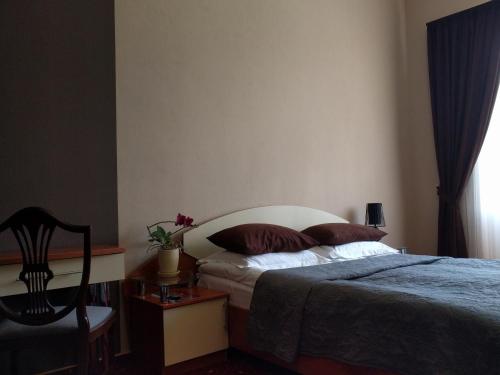 a bedroom with a bed and a desk and a chair at Kaiser Hotel in Chernivtsi