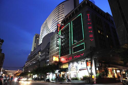 a building with a neon sign on the side of it at The Key Bangkok Hotel in Bangkok