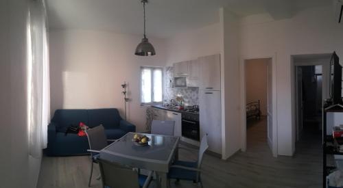 cocina y sala de estar con mesa y sofá azul en Casa del Geco, en Rinella