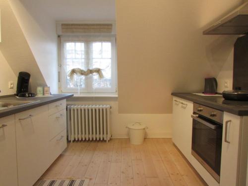 una cocina con armarios blancos y una ventana en Le Vicus en Eckbolsheim