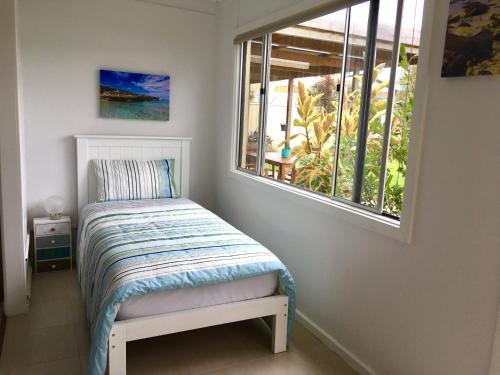 a small bedroom with a bed and a window at Island Daydreamer in Kingscote