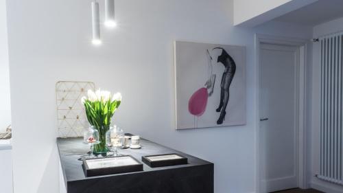 a room with a black counter with a vase of flowers at Le Logge in Parma