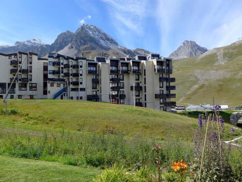 un bâtiment sur une colline avec des montagnes en arrière-plan dans l'établissement Studio Le Prariond - Val Claret-9 by Interhome, à Tignes
