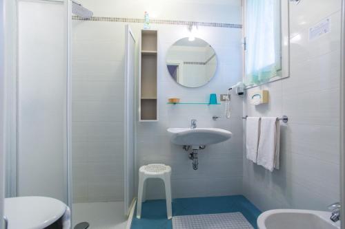 a white bathroom with a sink and a mirror at Hotel Donatello in Cesenatico