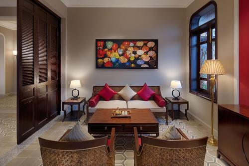 a living room with a couch and a table at Allegro Hoi An . A Little Luxury Hotel & Spa in Hoi An