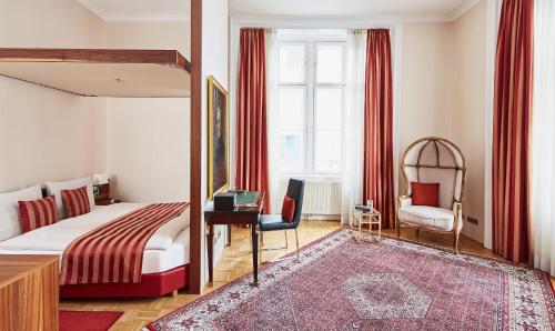 a bedroom with a bed and a desk and a chair at Living Hotel an der Oper in Vienna